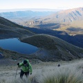 Trampers climbing tussock slopes