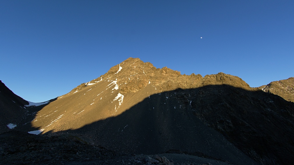 Sunlit unnamed peak 2,222 metres and the Moon