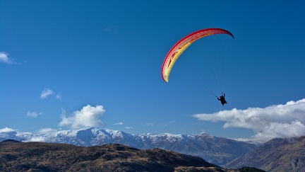 Tandem paraglider in the sky above Queenstown Hill