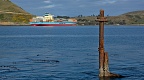Mast of a sunken ship at Aramoana mole and container ship passin