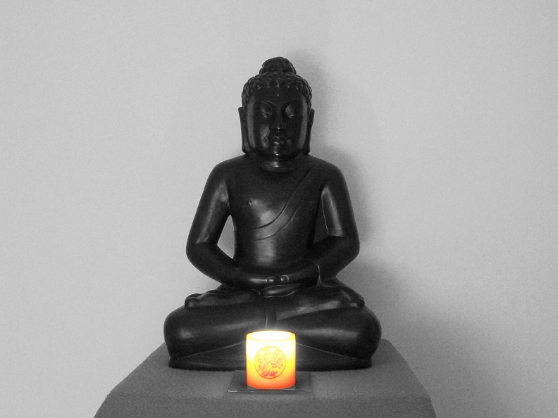 Buddha sitting with candle