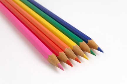 Six parallel colour pencils on a flat surface