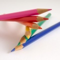 Six bright colour pencils stacked on top of each other