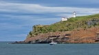 Taiaroa Head with lighthouse and wildlife cruise boat