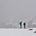 Two trampers at Lake Harris in grey cloud