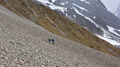 Two trampers climbing up scree slope