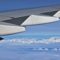 Airplane wing with jet engine and Southern Alps
