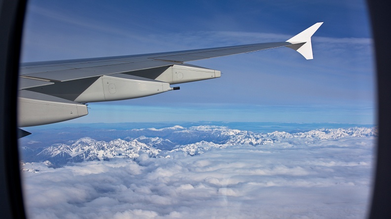 Airplane wing and Southern Alps through a window