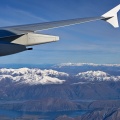 Airplane wing, mountains, and a lake