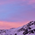 Pink sky and snowy mountain peak