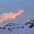 Pinky cloud and first sunrays on a mountain top
