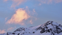 Pinky cloud formation above a snowy mountain top