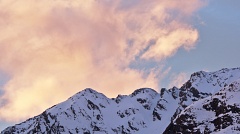Snowy mountains and large pinky clouds